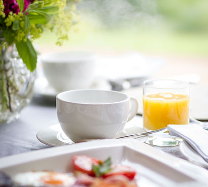A freshly served breakfast with orange juice, tea and pastries